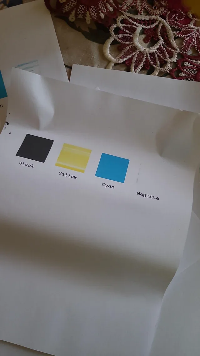 Photographed printer test with the magenta-looking reference area missing while other color areas remain visible